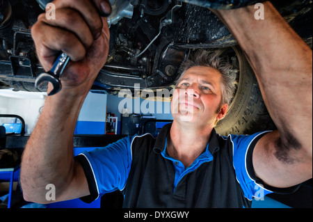 Mechaniker arbeiten unter dem Auto Stockfoto