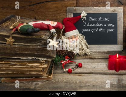 Vintage Weihnachts-Dekoration mit antiken Spielsachen und rote Kerze auf hölzernen Hintergrund. Stockfoto