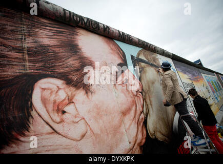 Berlin, Deutschland. 27. April 2014. Künstlers Dimitri Vrubel (L) und Sohn Artjom reinigen das Graffiti-Gemälde von der sozialistischen brüderlichen Kuss an der East Side Gallery in Berlin, Deutschland, 27. April 2014. Menschen und Touristen gereinigt den 1,3 km langen Abschnitt der Berliner Mauer nahe dem Zentrum von Berlin. Foto: KAY NIETFELD/Dpa/Alamy Live News Stockfoto