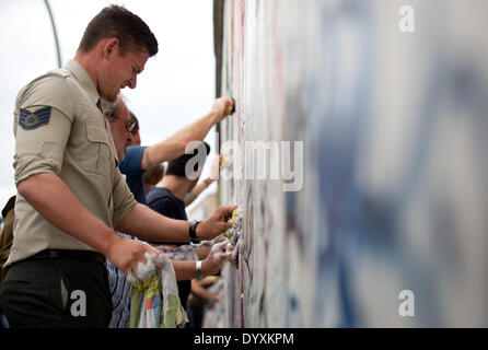 Berlin, Deutschland. 27. April 2014. Menschen reinigen Graffiti Gemälde in der East Side Gallery in Berlin, Deutschland, 27. April 2014. Künstlergruppe Menschen und Touristen zur Reinigung des 1,3 km langen Abschnitts der Berliner Mauer in der Nähe von Berlin-Mitte. Foto: KAY NIETFELD/Dpa/Alamy Live News Stockfoto