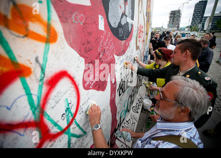 Berlin, Deutschland. 27. April 2014. Menschen reinigen Graffiti Gemälde in der East Side Gallery in Berlin, Deutschland, 27. April 2014. Künstlergruppe Menschen und Touristen zur Reinigung des 1,3 km langen Abschnitts der Berliner Mauer in der Nähe von Berlin-Mitte. Foto: KAY NIETFELD/Dpa/Alamy Live News Stockfoto