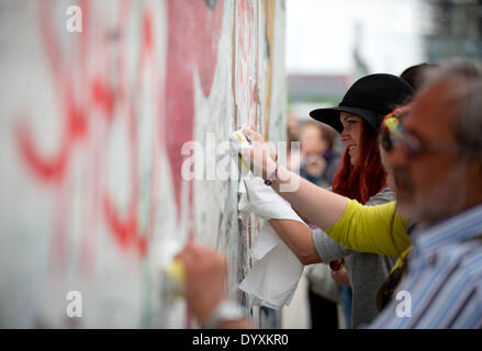 Berlin, Deutschland. 27. April 2014. Menschen reinigen Graffiti Gemälde in der East Side Gallery in Berlin, Deutschland, 27. April 2014. Künstlergruppe Menschen und Touristen zur Reinigung des 1,3 km langen Abschnitts der Berliner Mauer in der Nähe von Berlin-Mitte. Foto: KAY NIETFELD/Dpa/Alamy Live News Stockfoto