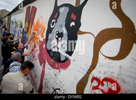 Berlin, Deutschland. 27. April 2014. Menschen reinigen Graffiti Gemälde in der East Side Gallery in Berlin, Deutschland, 27. April 2014. Künstlergruppe Menschen und Touristen zur Reinigung des 1,3 km langen Abschnitts der Berliner Mauer in der Nähe von Berlin-Mitte. Foto: KAY NIETFELD/Dpa/Alamy Live News Stockfoto