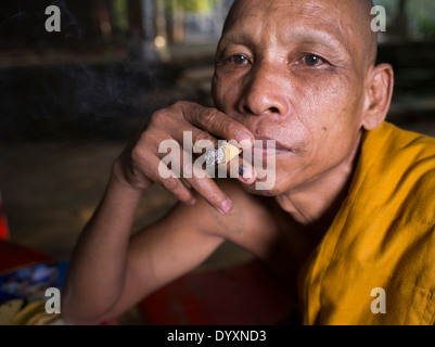 Kambodschanische buddhistischer Mönch Handrolled Zigarre rauchen gemacht mit Sankai Blatt neben Bayon Tempel, Angkor Thom, Siem Reap, Kambodscha Stockfoto
