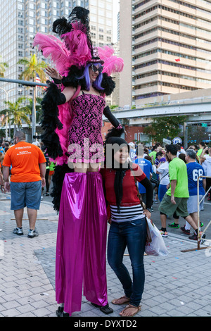 Weibliche Stelzenläufer Walker in bunten Kostümen mit junge Frau Zuschauer am 2014-Mercedes-Benz Corporate Durchlauf in Miami, Florida, USA. Stockfoto