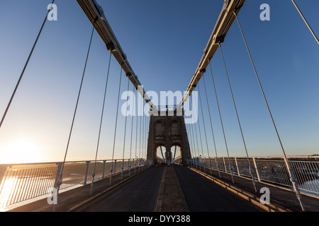 Die Menai Hängebrücke eine Hängebrücke, bei Sonnenuntergang, zwischen der Insel Anglesey und dem Festland von Wales. Stockfoto