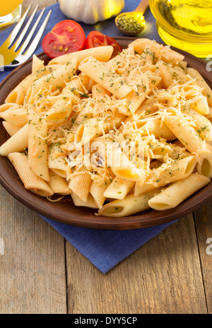 Pasta Penne in Platte auf hölzernen Hintergrund Stockfoto