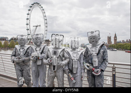 London, 27. April 2014 - Leute angezogen, wie ihre Lieblings Sci-Fi-Charaktere in der Sci-Fi London 2014 Trachtenumzug im Somerset House beginnend und endend beim BFI auf der South Bank teilnehmen.  Cybermen auf Hungerford Bridge, mit dem London Eye und die Houses of Parliament in der Ferne.    Bildnachweis: Stephen Chung/Alamy Live-Nachrichten Stockfoto