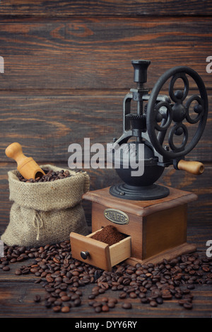 Vintage Kaffeemühle mit Kaffeebohnen auf hölzernen Hintergrund Stockfoto