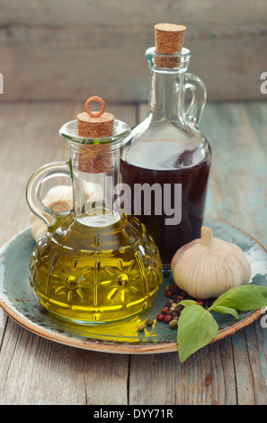 Olivenöl und Weinessig in Flaschen auf hölzernen Hintergrund Stockfoto