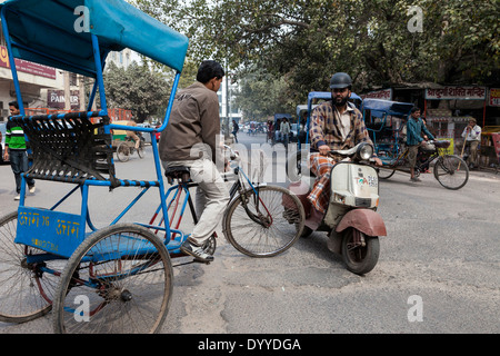 Neu-Delhi, Indien. Verkehr-Begegnung, Rikscha und Motorrad, die Innenstadt von Delhi Street. Stockfoto