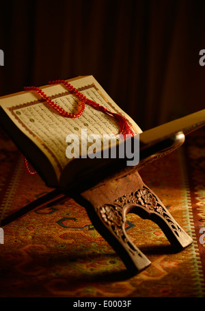 Heiliger Koran und Rosenkranz Perlen auf einem Holzständer Stockfoto