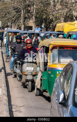 Neu-Delhi, Indien. Verkehr auf einer Straße in Delhi: Rikschas, Motorräder, Autos. Stockfoto