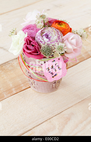 Schöner Blumenstrauß Frühlingsblumen in Blumentopf und eine Karte mit dem Text "Ich liebe dich Mama" Stockfoto
