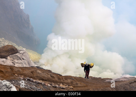 Mann mit Körben beladen mit Blöcken von Schwefel, Kawah Ijen, Banyuwangi Regency, Ost-Java, Indonesien Stockfoto
