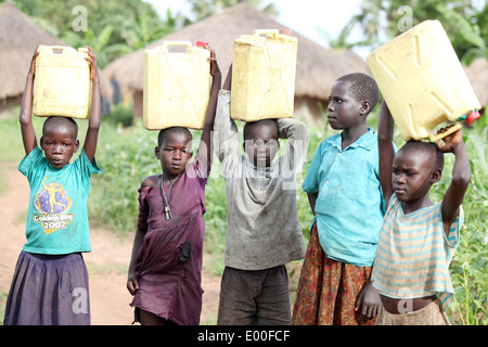 Junge Kinder ausklingen ihren Tag durch schmutziges Wasser für ihre Familien im Bezirk Lira in Norduganda zu sammeln Stockfoto