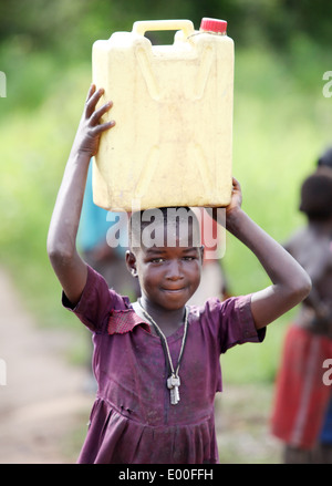 Kinder sammeln Wasser aus einer unreinen Regierung Wasserquelle in den Kosovo Slumviertel der Stadt Kampala in Uganda. Stockfoto