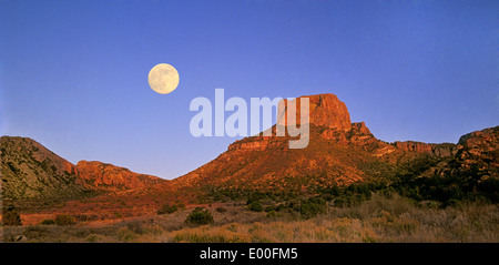 Ein Vollmond steigt über die Chisos Berge in Big Bend Nationalpark, Texas Stockfoto