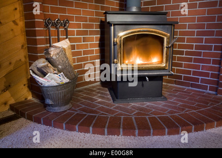 Detail eines Holz-brennenden Ofen im Wohnzimmer eines hölzernen Hauses. Stockfoto