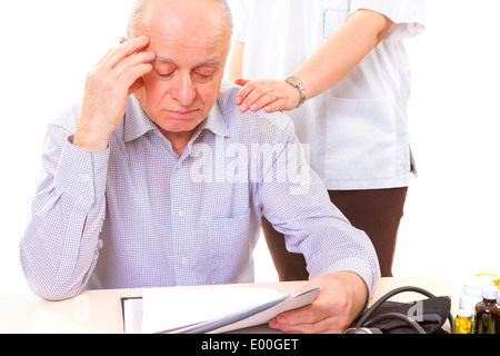 Arzt beruhigend Reife gestresste Patienten mit Kopfschmerzen Stockfoto