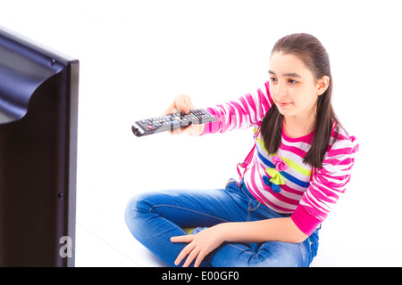 Glückliches kleines Mädchen Festlegung und vor dem Fernseher auf weißem Hintergrund Stockfoto