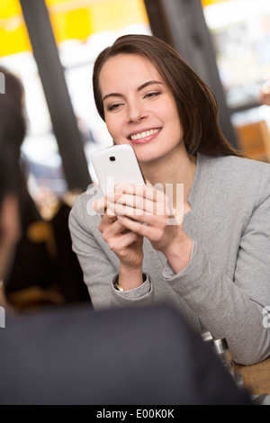 Weiblich männlich fröhlich Smartphone Abendessen Bar Foto Stockfoto