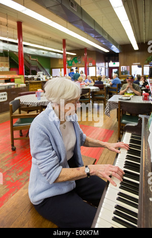 83 Jahre alte Frau spielt Klavier im Pizza-Restaurant Stockfoto