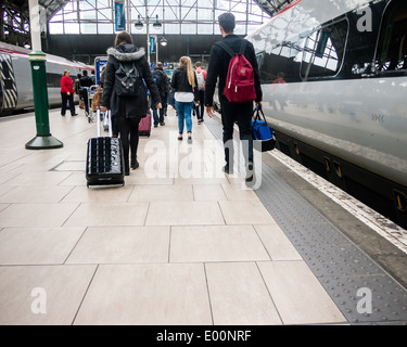 Passagiere auf einem Bahnhof entlang einer Plattform nach dem Aussteigen eines Virgin Rail-Zuges. Stockfoto