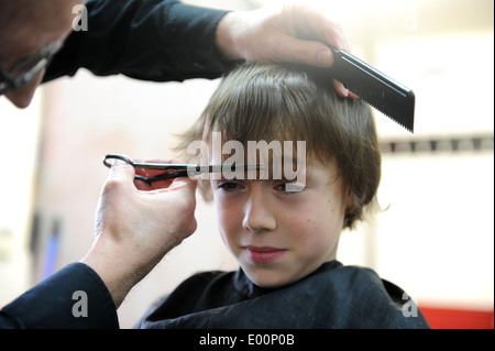 9 Jahre alten Schüler, die einen Haarschnitt in Barbiere in Great Ayton, North Yorkshire, England uk Stockfoto