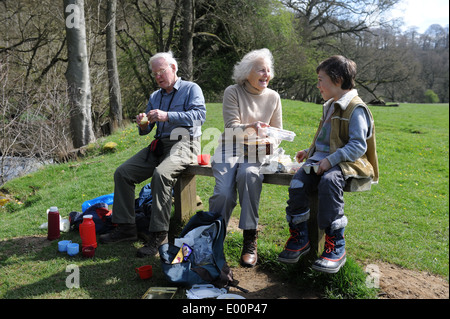 Großeltern und Enkel entspannen Sie sich auf eine Bank bei einem Spaziergang in North yorkshire Stockfoto