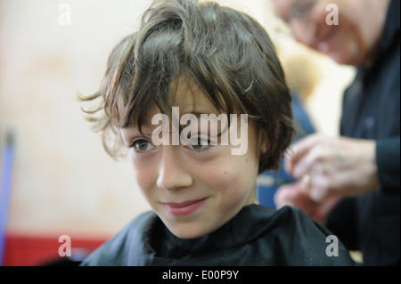 9 Jahre alten Schüler, die einen Haarschnitt in Barbiere in Great Ayton, North Yorkshire, England uk Stockfoto