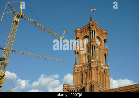 Rathaus von Berlin, Rotes Rathaus am Alexanderplatz im Sonnenlicht mit Krane vor, benannt. Stockfoto