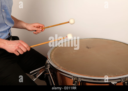 Pauken-Spieler spielt im richtigen Spielbereich ein Kalb-headed Trommel um die beste Klangqualität zu produzieren. Stockfoto