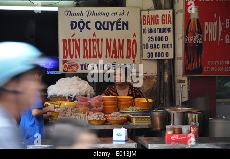 Eine Frau sitzt in ihrer Straße Garküche Verkauf Bun Rieu Nam Bo in der alten 36 Straßen des Viertels in Hanoi, der Hauptstadt von Vietnam Stockfoto