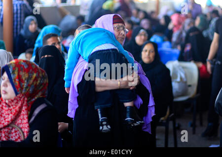 Gaza, Palästinensische Gebiete. 29. April 2014. Eine palästinensische Frau trägt ihr Baby wie sie hofft, dass in Ägypten an den Grenzübergang Rafah zwischen Ägypten und dem südlichen Gazastreifen 29. April 2014 zu überqueren. Ägyptische Behörden wieder teilweise Grenzübergang Rafah für zwei Tage nach der palästinensischen Versöhnung zwischen Hamas und Fatah Parteien eröffnet. Ahmed Deeb/NurPhoto/ZUMAPRESS.com/Alamy © Live-Nachrichten Stockfoto