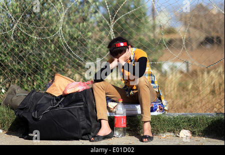 Gaza, Palästinensische Gebiete. 29. April 2014. Ein palästinensisches Mädchen sitzt neben ihr Gepäck wartet sie in Ägypten an den Grenzübergang Rafah zwischen Ägypten und dem südlichen Gazastreifen 29. April 2014 zu überqueren. Ägyptische Behörden wieder teilweise Grenzübergang Rafah für zwei Tage nach der palästinensischen Versöhnung zwischen Hamas und Fatah Parteien eröffnet. Ahmed Deeb/NurPhoto/ZUMAPRESS.com/Alamy © Live-Nachrichten Stockfoto