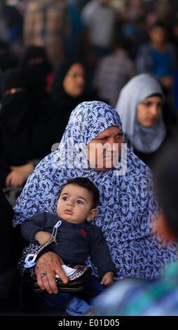 Gaza, Palästinensische Gebiete. 29. April 2014. Eine palästinensische Frau trägt ihr Baby wie sie hofft, dass in Ägypten an den Grenzübergang Rafah zwischen Ägypten und dem südlichen Gazastreifen 29. April 2014 zu überqueren. Ägyptische Behörden wieder teilweise Grenzübergang Rafah für zwei Tage nach der palästinensischen Versöhnung zwischen Hamas und Fatah Parteien eröffnet. Ahmed Deeb/NurPhoto/ZUMAPRESS.com/Alamy © Live-Nachrichten Stockfoto
