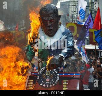 Manila, Philippinen. 28. April 2014. Demonstranten setzen ein Bildnis von uns Präsident Barack Obama hält eine Leine mit philippinische Präsident Benigno Aquino III am anderen Ende (nicht abgebildet) brennt nach marschieren in Richtung eines der Tore des Präsidentenpalastes willkommen Obama mit Protesten in seinem Staat zu besuchen in Manila. Verschiedene Gruppen halten die Proteste, die angeblichen großen Neuordnung der US-Streitkräfte in der Vorbereitung für einen großen Krieg, verborgen hinter seinem "Asien Pivot" Programm zu verurteilen. George Calvelo/NurPhoto/ZUMAPRESS.com/Alamy © Live-Nachrichten Stockfoto