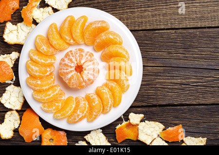 Geschälte Mandarine und Rinde auf alten Holztisch Stockfoto