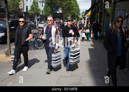 Drei Männer, die an Joseph eingekauft haben entlang der Kings Road in Chelsea. London, UK. Stockfoto