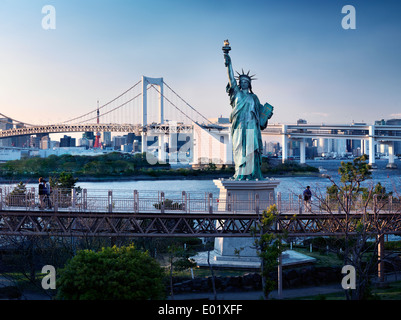 Freiheitsstatue mit Rainbow Bridge im Hintergrund in Odaiba, Tokio, Japan. Stockfoto