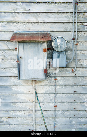 Haushaltsstrom Meter an der Außenwand ein altes verlassenes Haus. Stockfoto