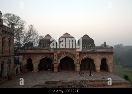 Menschen, die Yoga praktizieren, in den frühen Morgenstunden am Mehman Khana, Lodhi Gärten, Neu-Delhi, Indien, Stockfoto