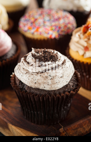 Ausgefallene Gourmet Muffins mit Zuckerguss auf einem Hintergrund sortiert Stockfoto
