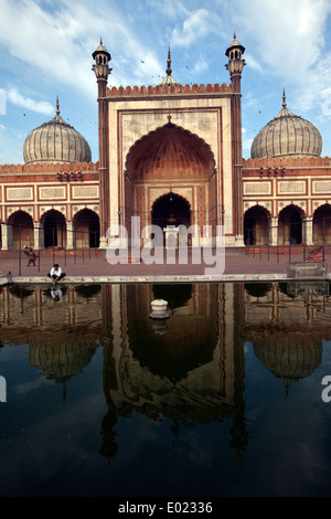 Ein Mann wäscht rituell in einem Pool, der reflektiert die Jama Masjid (Freitagsmoschee), Alt-Delhi, Indien Stockfoto