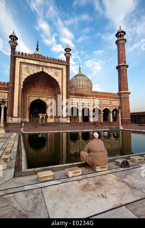 Ein Mann wäscht rituell in einem Pool, der reflektiert die Jama Masjid (Freitagsmoschee), Alt-Delhi, Indien Stockfoto