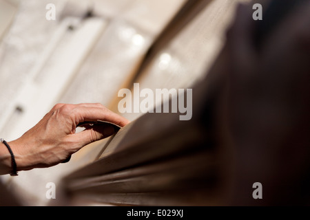 Hände einer Frau mit Sandpapier tun DIY arbeiten auf hölzernen Befestigungen Stockfoto