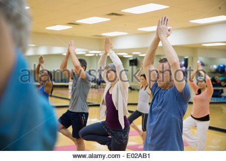 Gruppe praktizierender Baumpose im Yoga-Kurs