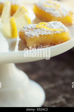 Pikanter süße Zitrone Bars mit Zitrone garnieren und Zucker des Konditors Stockfoto