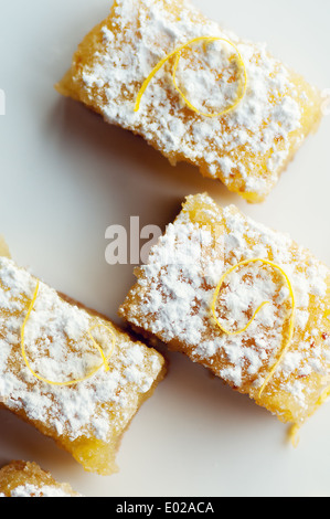 Pikanter süße Zitrone Bars mit Zitrone garnieren und Zucker des Konditors Stockfoto